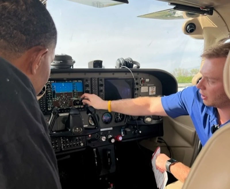 Flight Instructor making explanation to student inside aircraft cockpit